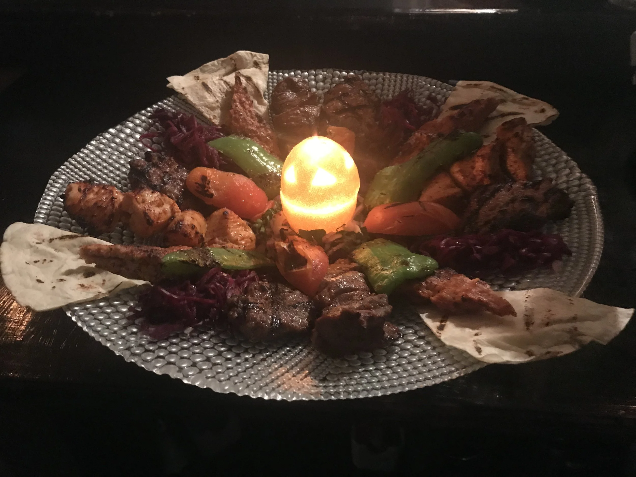 Mixed grill — kebabs around warm pita and candlelight