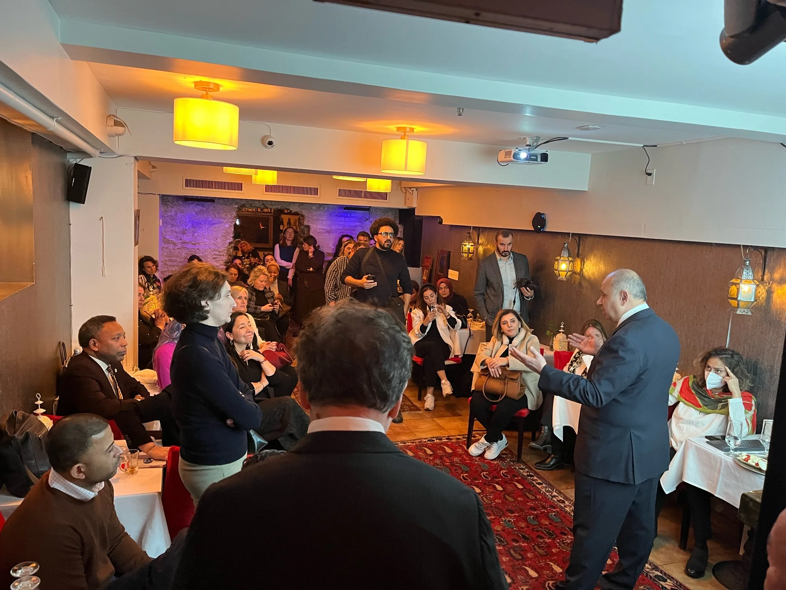 A live event in the cave room — speaker, audience, celebration