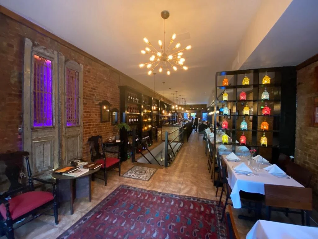 Front lounge — brick walls, sputnik chandelier, Moroccan lanterns