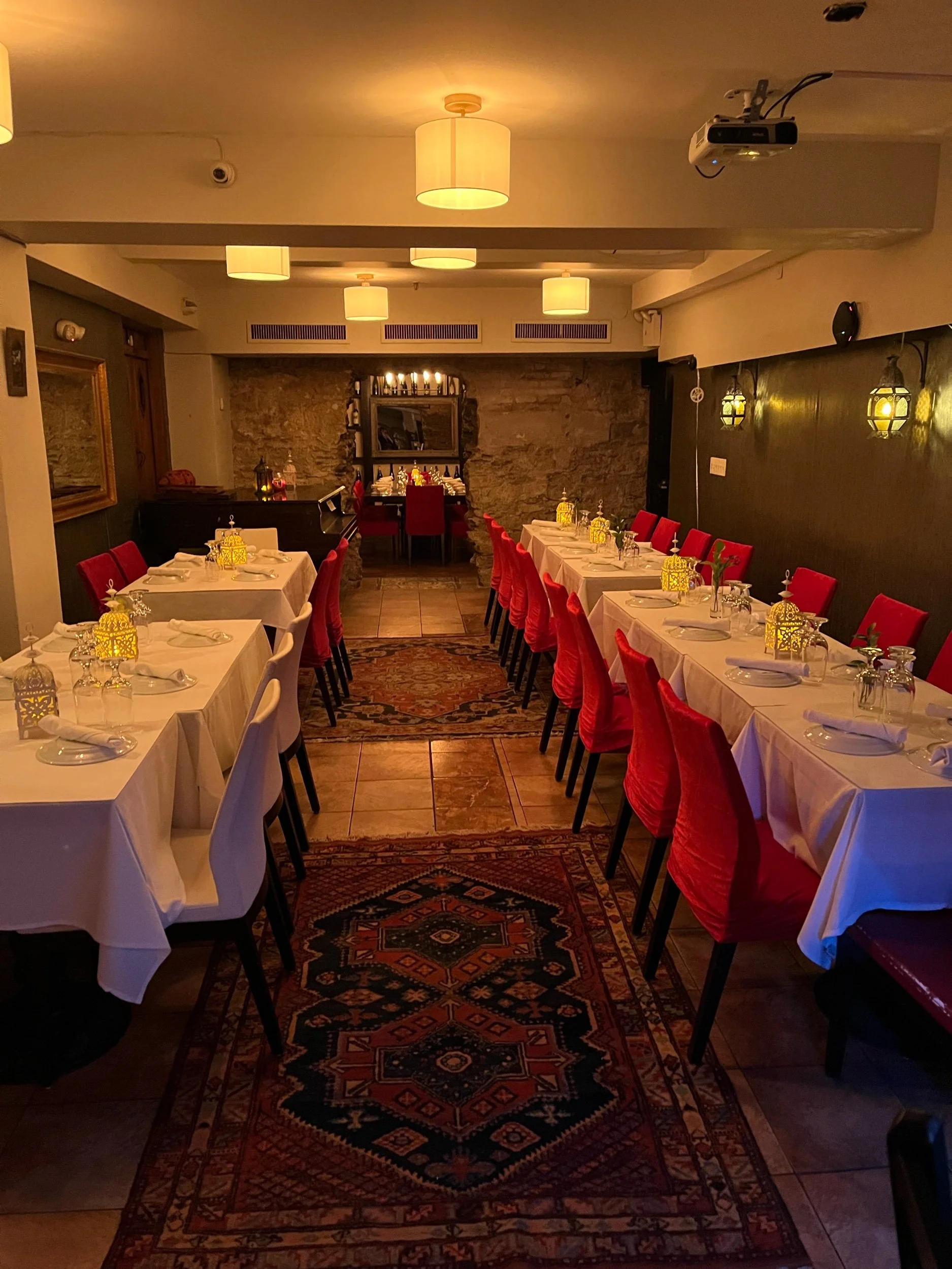 Private dining room — red chairs, Persian rugs, set for a party